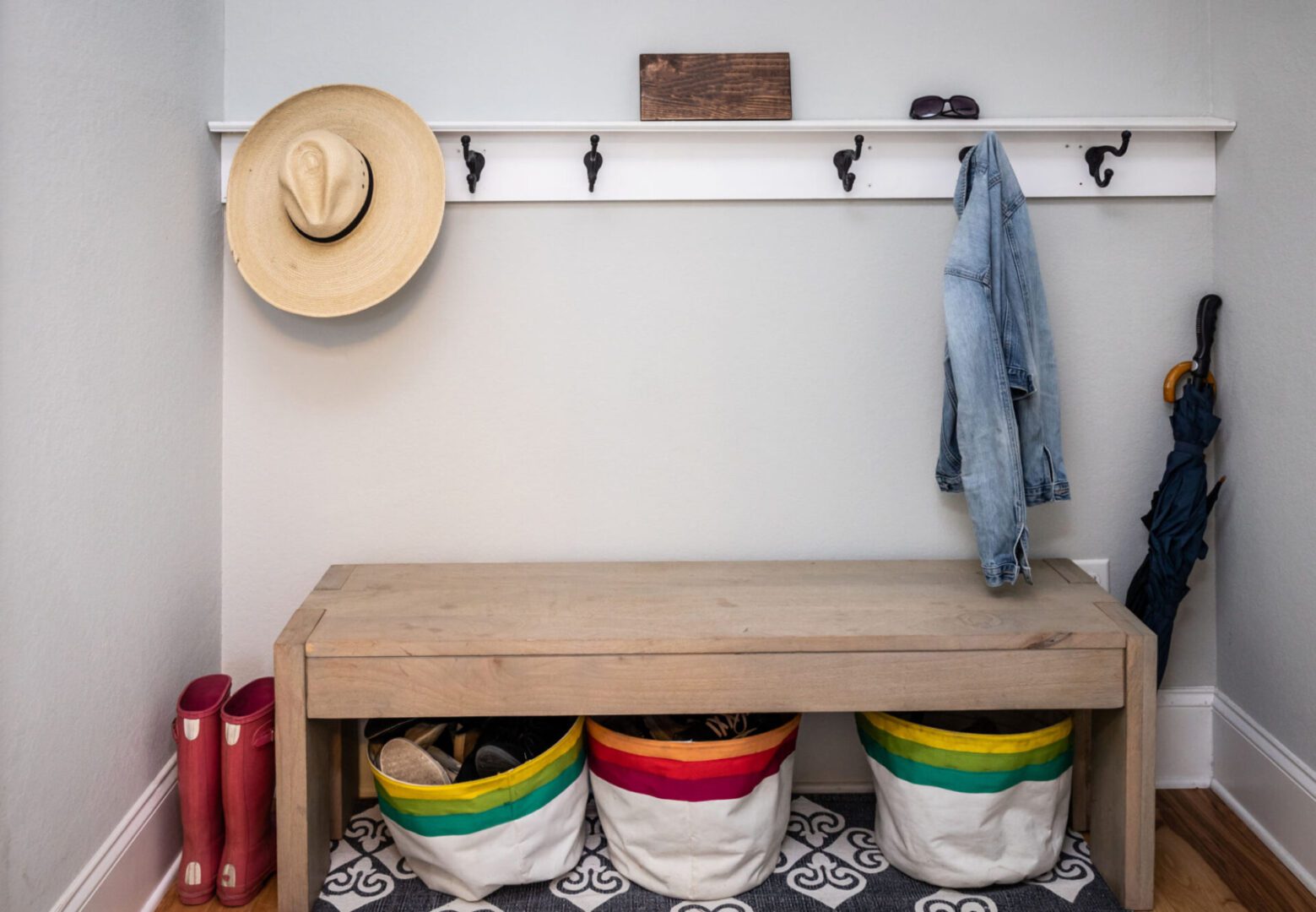 Entryway with bench, hat, coat, and boots.
