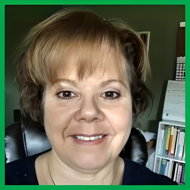 Smiling woman with short light brown hair in a home office.