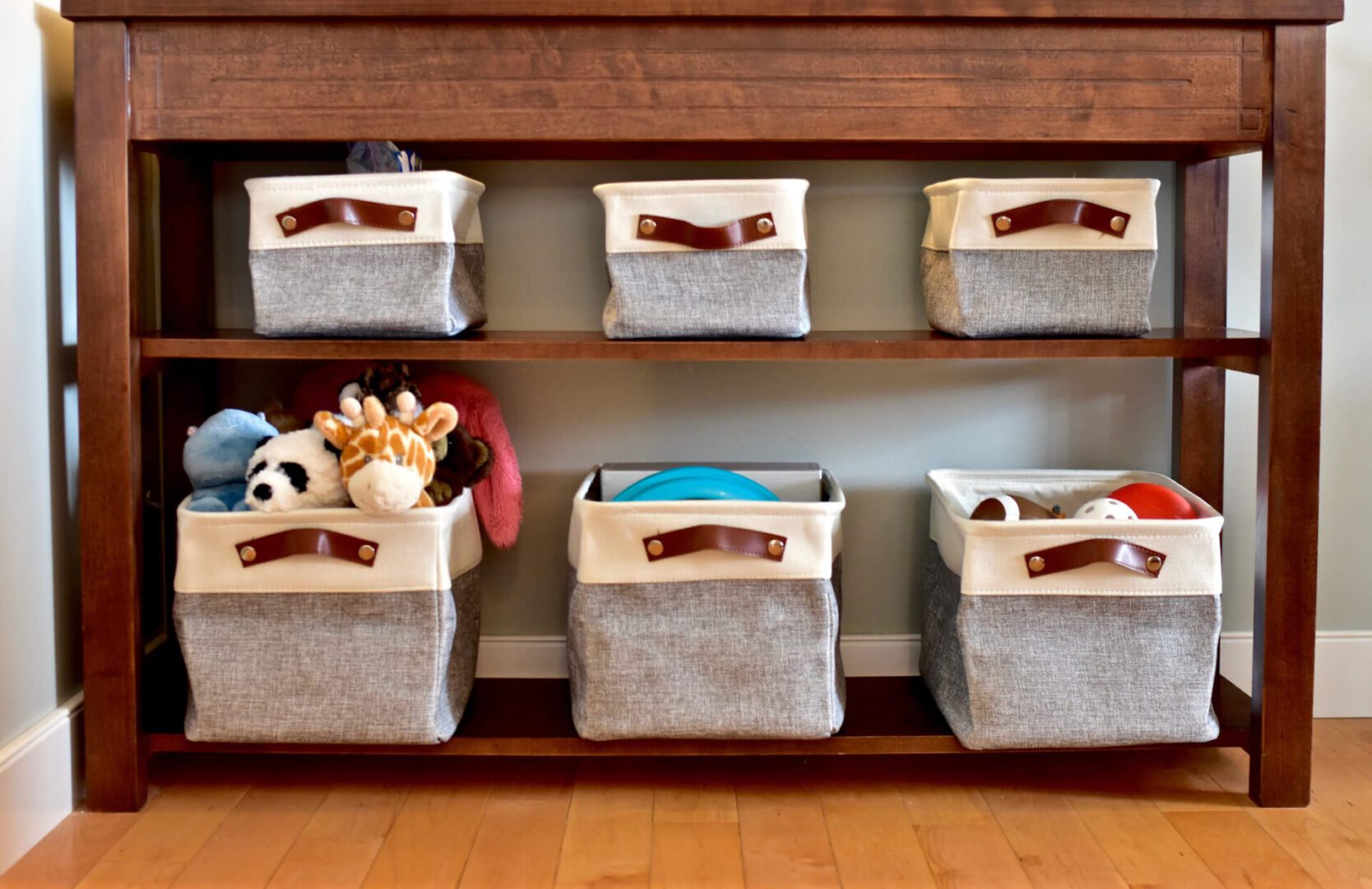 Toy storage baskets on a wooden shelf.